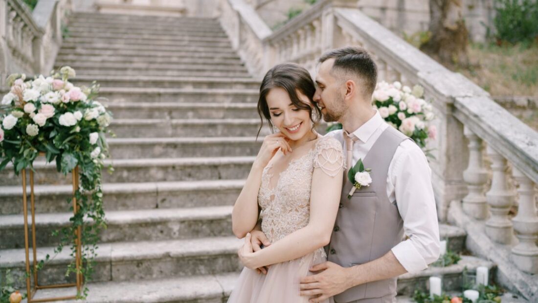 A bride and groom embracing on château steps after their ceremony — a romantic moment that shows why couples get married in France.