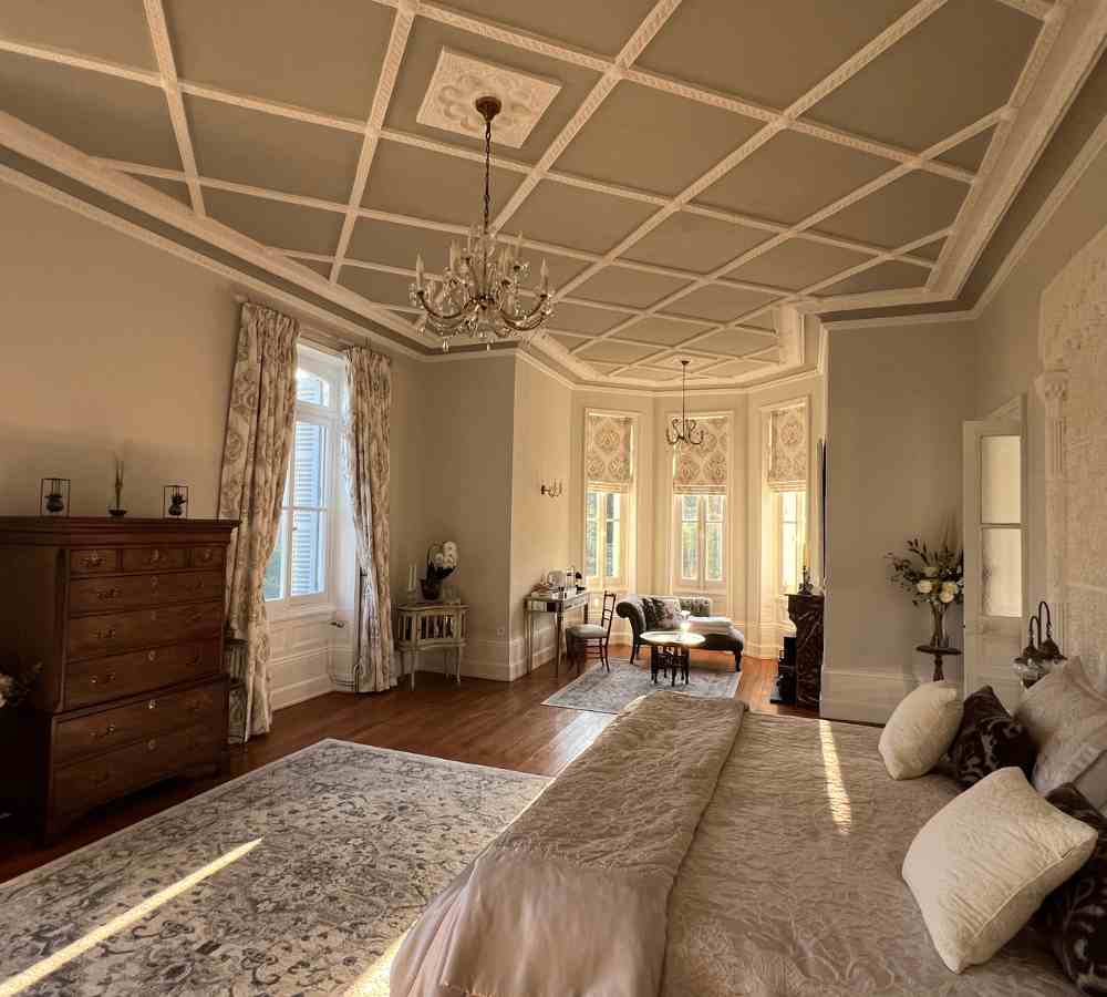Grand bridal suite with chandeliers, seating area and high ceilings, perfect for romantic escapes at Château de la Boutinière.