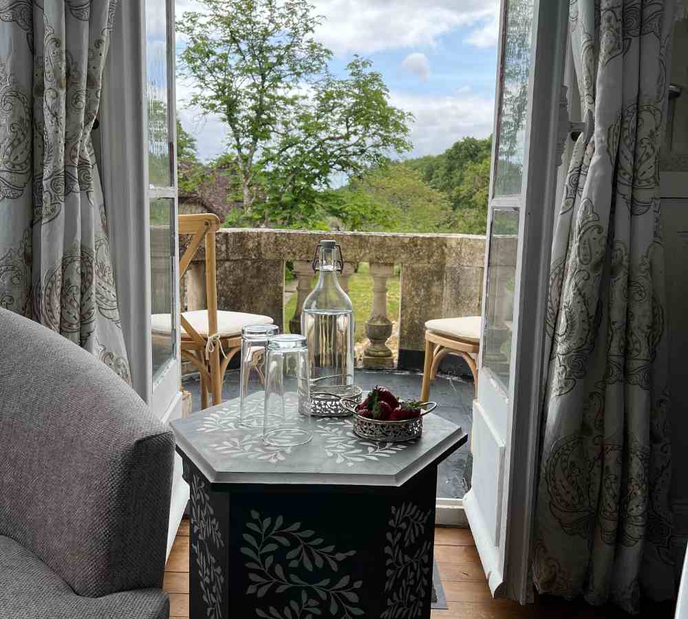 View from the bridal suite onto a private balcony overlooking the gardens, a peaceful setting for romantic escapes at Château de la Boutinière.