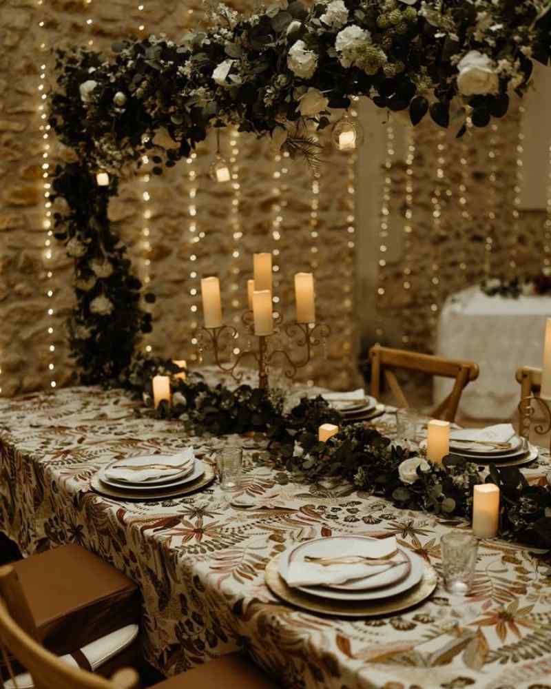 Intimate candlelit dining table with floral garlands and soft lighting, set for a celebration at a micro wedding venue at Château de la Boutinière.
