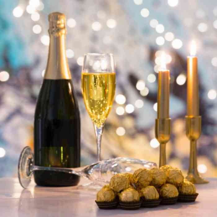 Bottle of sparkling wine with glasses and chocolates set for a special occasion at Château de la Boutinière.