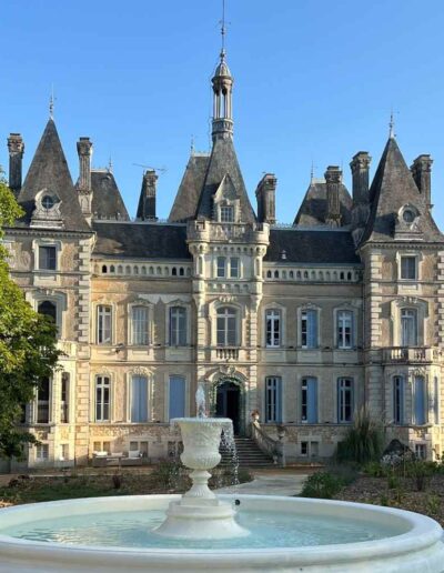 Front view of Château de la Boutinière on a clear day, with the fountain and steps used for fairytale wedding photographs