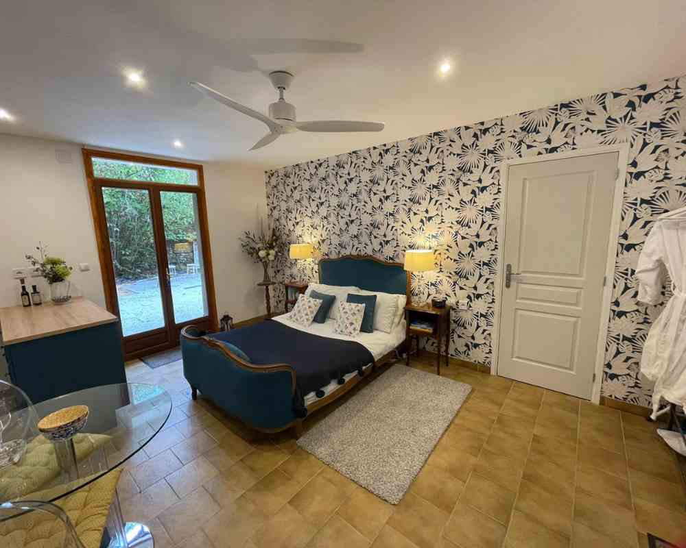 Gites in France showing a spacious self-catering gite at Château de la Boutinière, with a double bed, contemporary interior design and French doors opening onto the surrounding countryside.