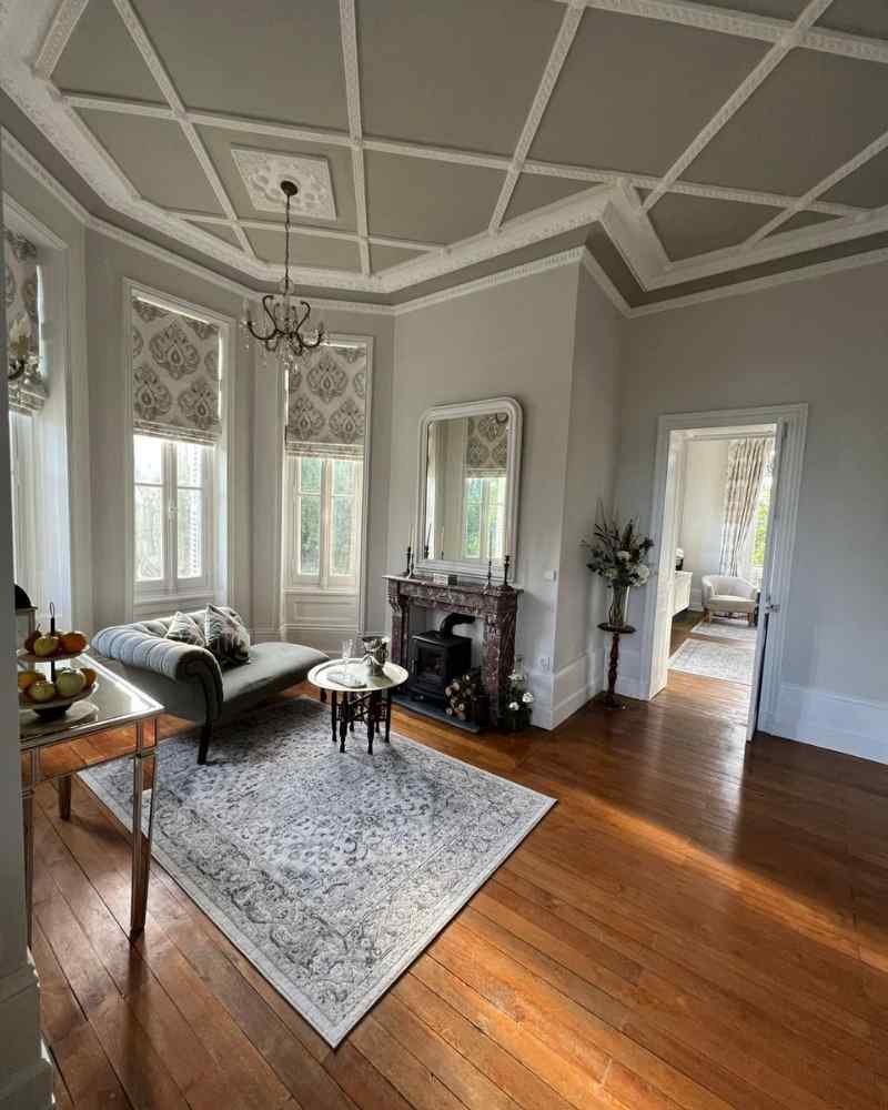 Reception room at Château de la Boutinière with patterned curtains, fireplace and seating area, fitted as part of work by our Château partners.
