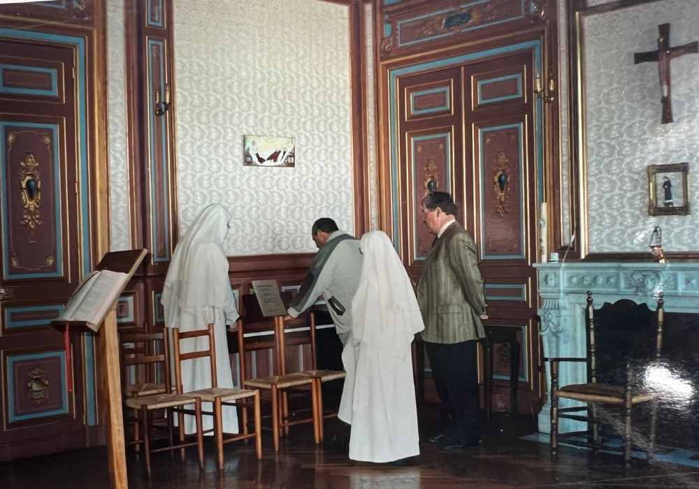 Château de la Boutinière historic interior photograph showing nuns gathered around a piano, reflecting daily life inside the château during its use as a religious residence.