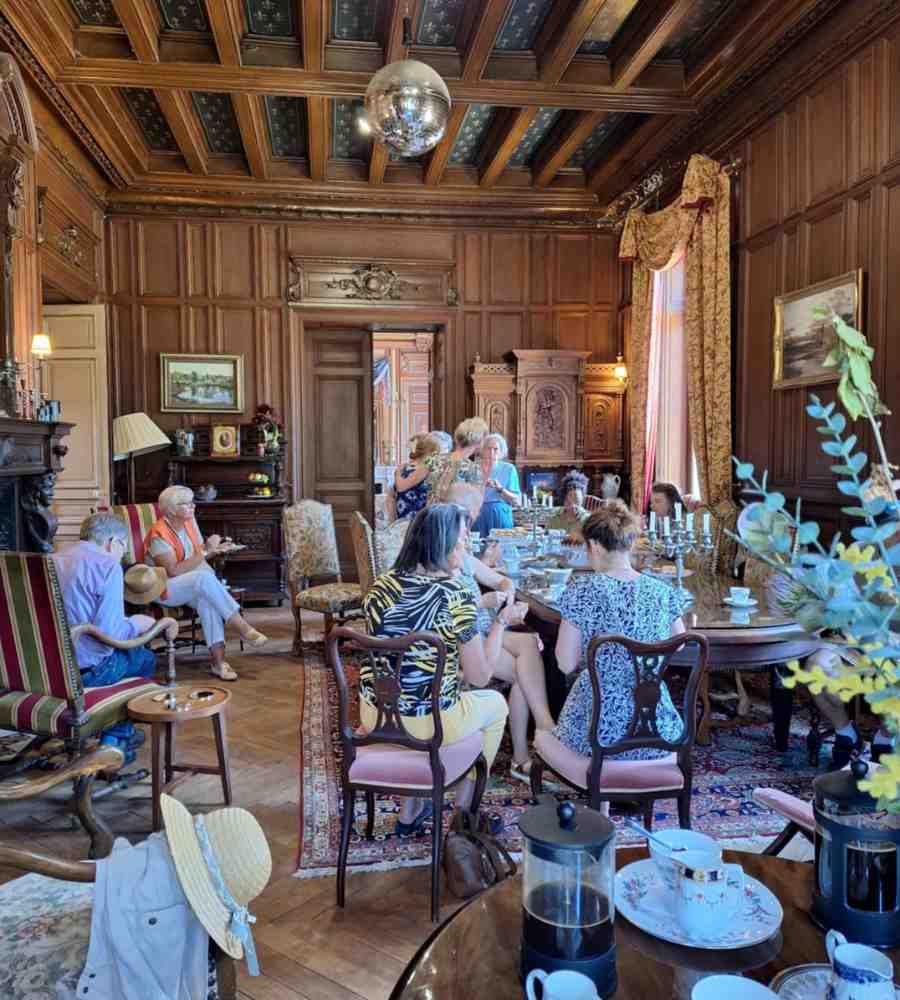 Chateau events inside Château de la Boutinière, showing guests seated together in a historic salon during a relaxed gathering with tea and conversation.