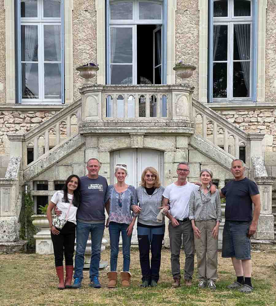 Chateau events group photo in front of Château de la Boutinière, showing guests and hosts gathered on the château steps during a behind-the-scenes estate event.