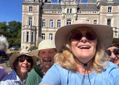 Chateau events gardening day selfie of four smiling women in sun hats with Château de la Boutinière in the background.