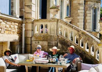 Chateau events gardening day with guests relaxing around a sofa table on the château terrace in bright spring sunshine.