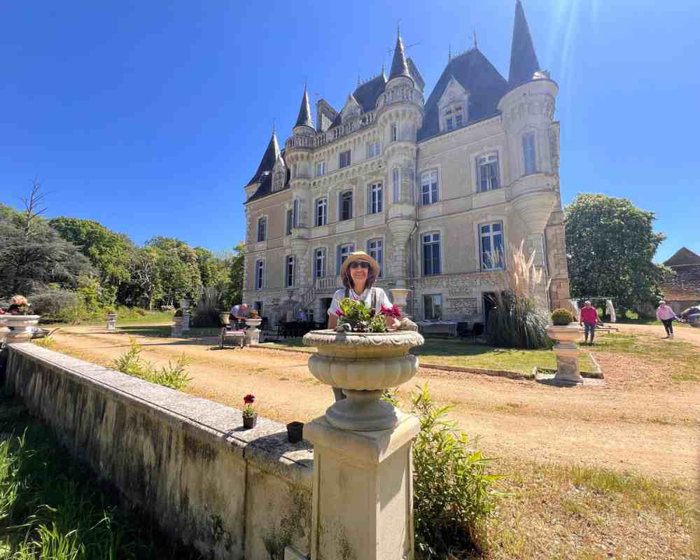Chateau events gardening day showing a wide front view of Château de la Boutinière with guests working in the grounds.