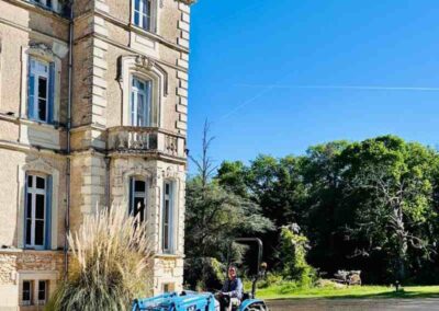 Chateau events gardening day at Château de la Boutinière with Zion driving a blue tractor across the front grounds.