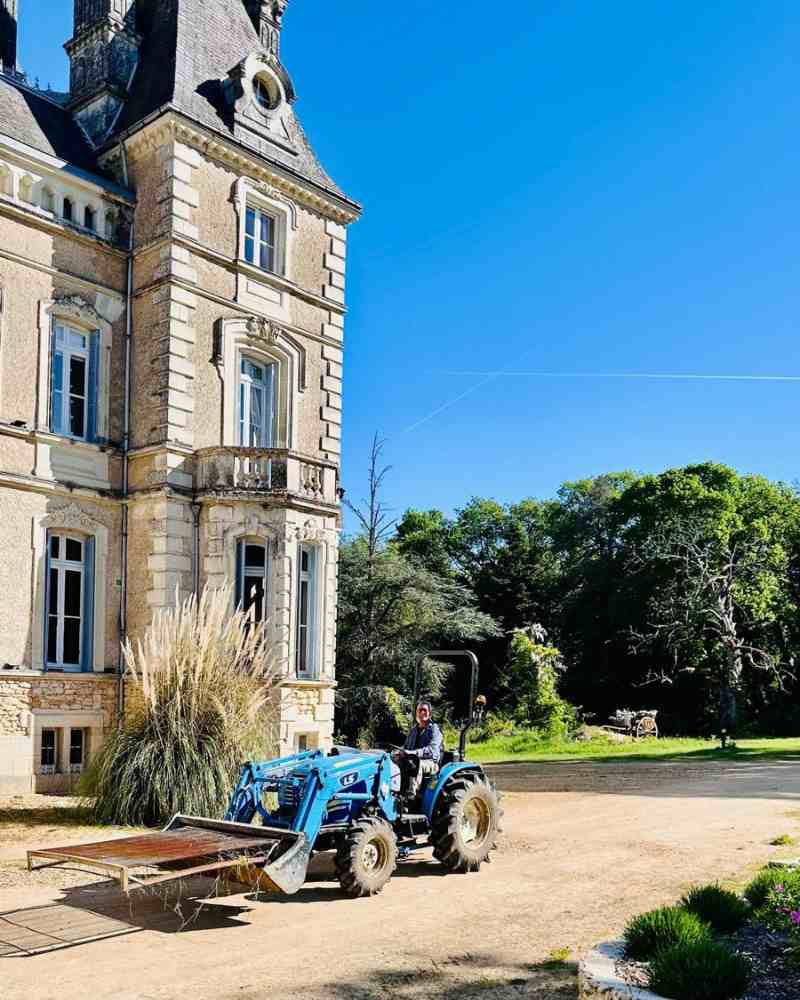 Chateau events gardening day at Château de la Boutinière with Zion driving a blue tractor across the front grounds.
