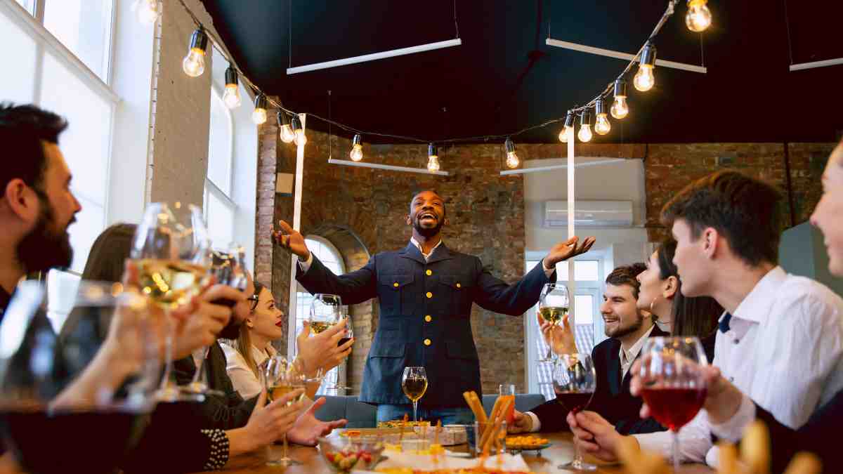 Guest speaking during a private dinner at a corporate retreat venue with colleagues seated around the table.