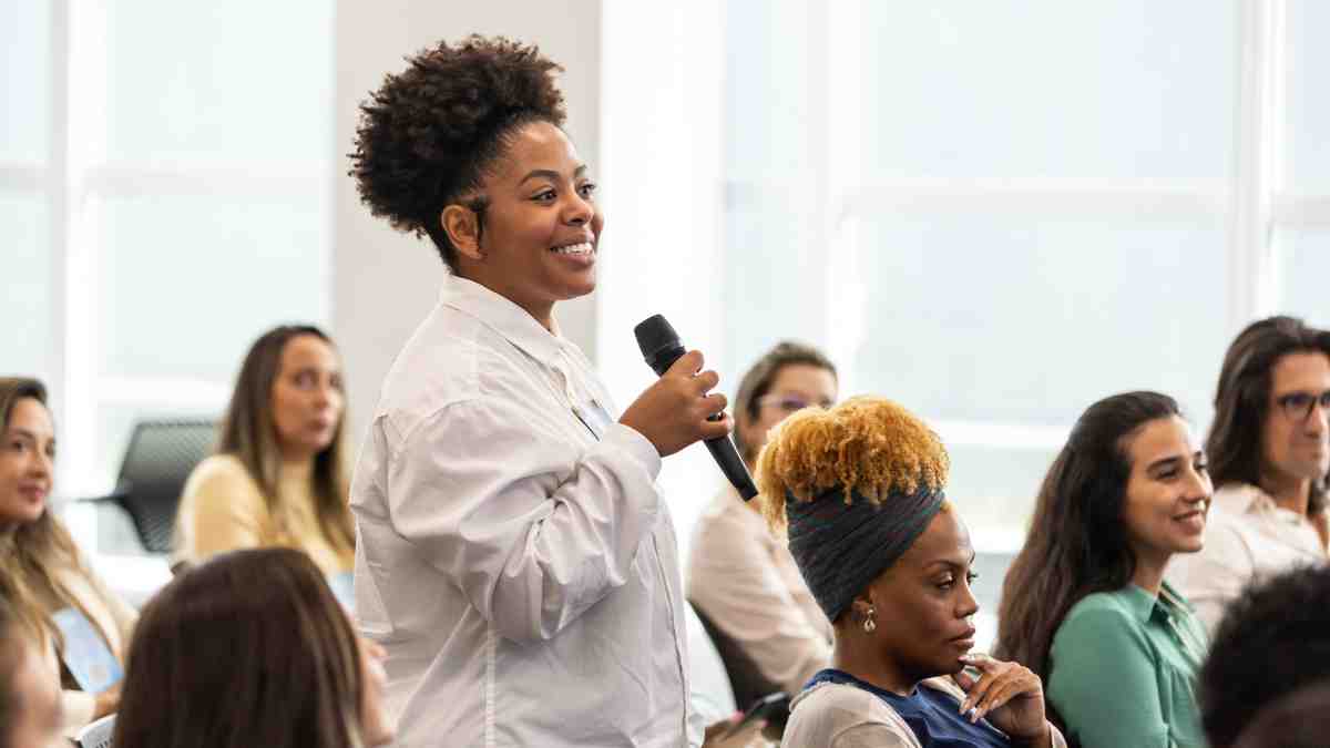 Woman asking a question during a group discussion at a corporate retreat venue.