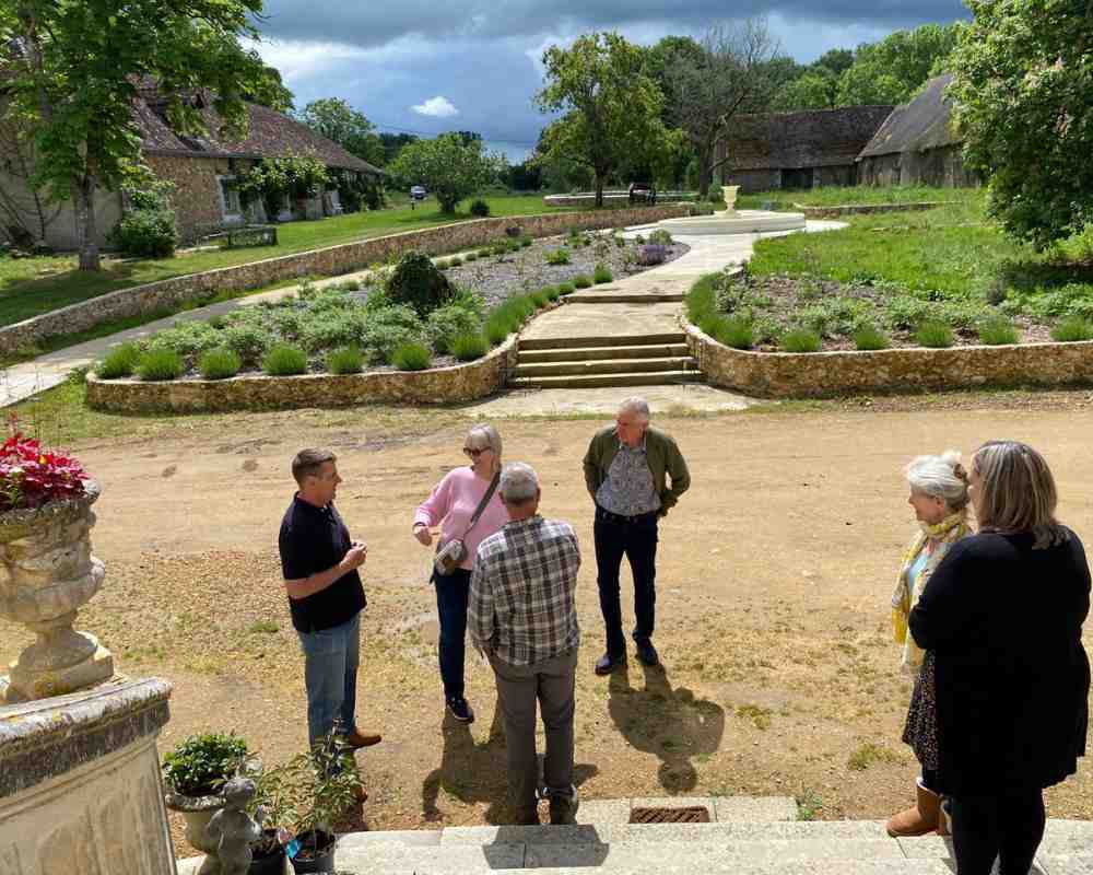 Guests gathered outside Château de la Boutinière during a Behind the Scenes Château Stay, with the gardens and fountain in view.