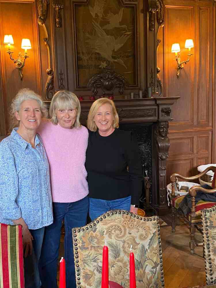 Three guests standing inside the grand salon during a Château Stay at Château de la Boutinière.