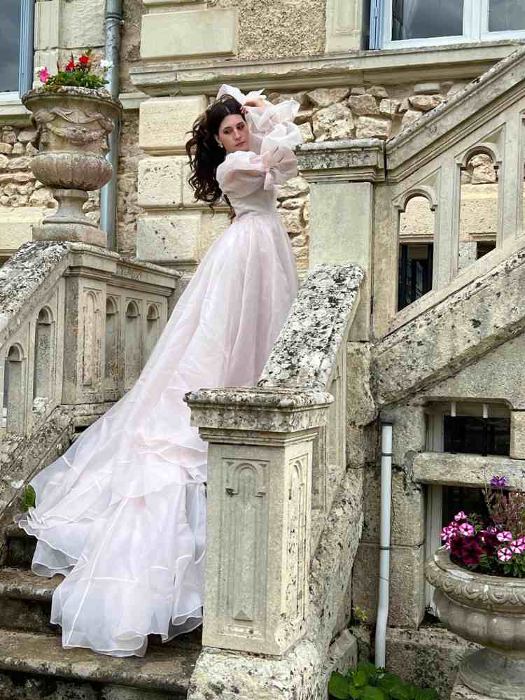 Doreen posing on the stone staircase at Château de la Boutinière during the photoshoot.